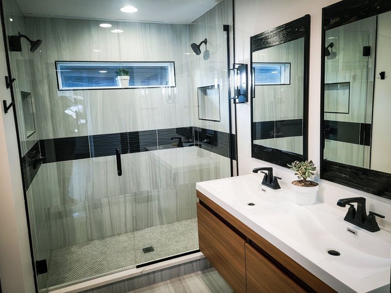 Remodeled bathroom with glass walk-in shower and double vanity