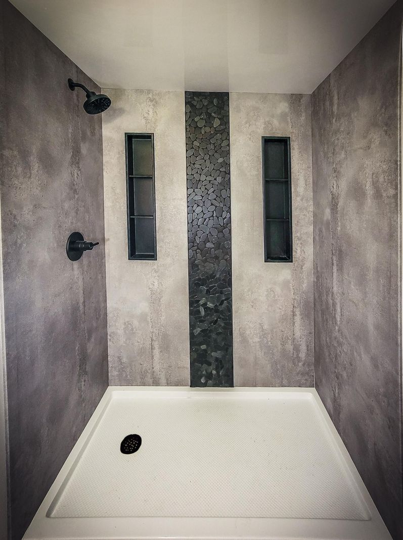 Shower with concrete-look walls and a dark tile accent strip