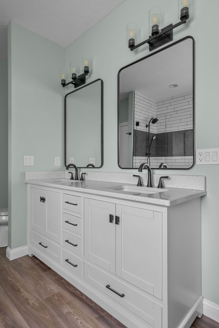 White double vanity with black arched mirrors
