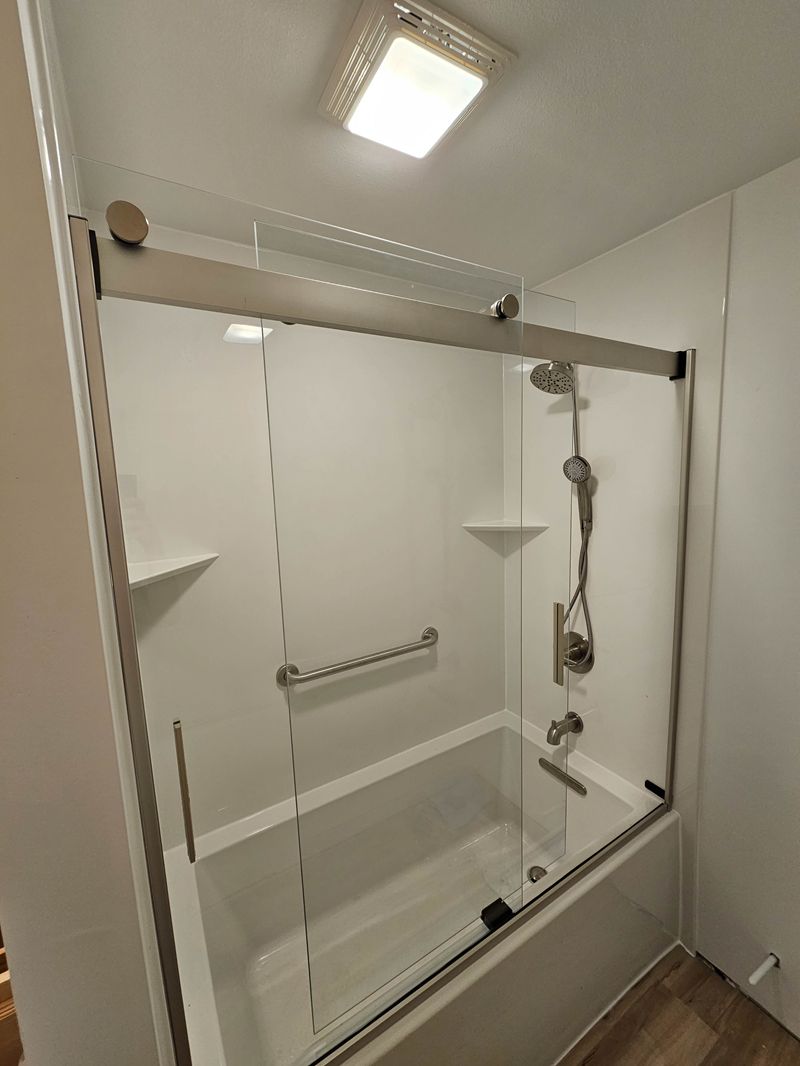 Standard White shower style with white walls and sliding glass doors